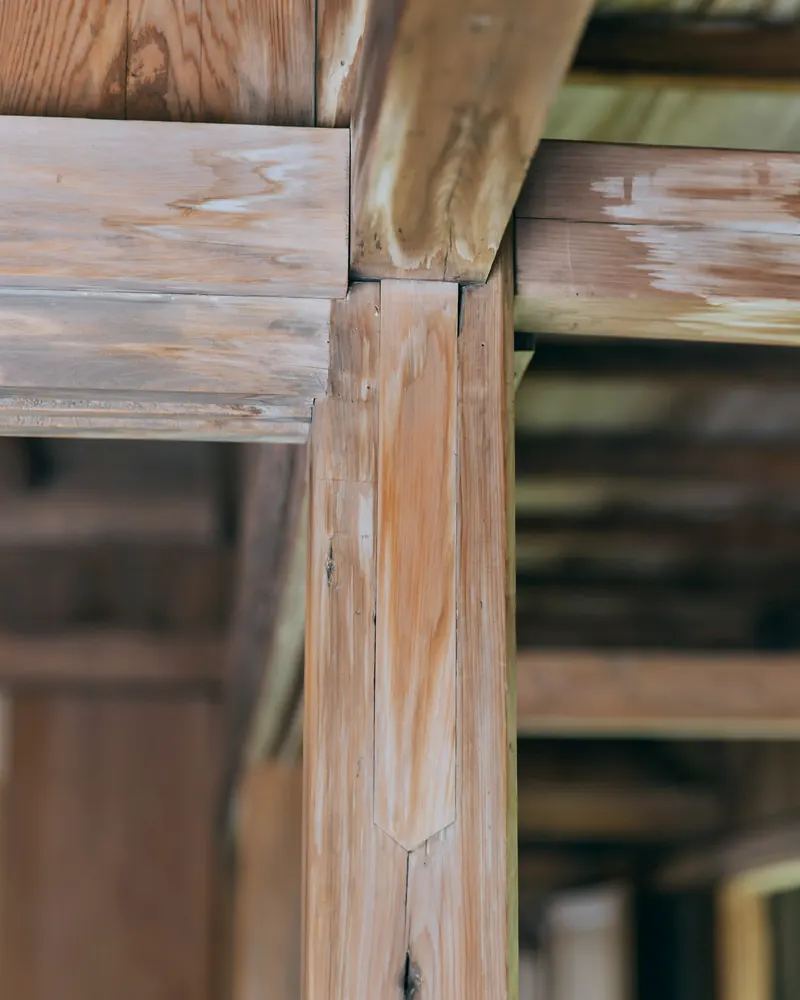 Assemblage d'une poutre et d'un poteau en bois dans un bâtiment ancien, gros plan sur le bois patiné