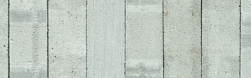Mur de parpaings gris clair, empilés en rangées régulières