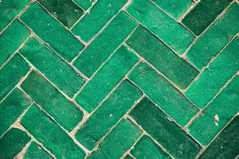 Zelliges verts émaillés posés en chevrons, avec leurs nuances de cuisson et leurs joints clairs